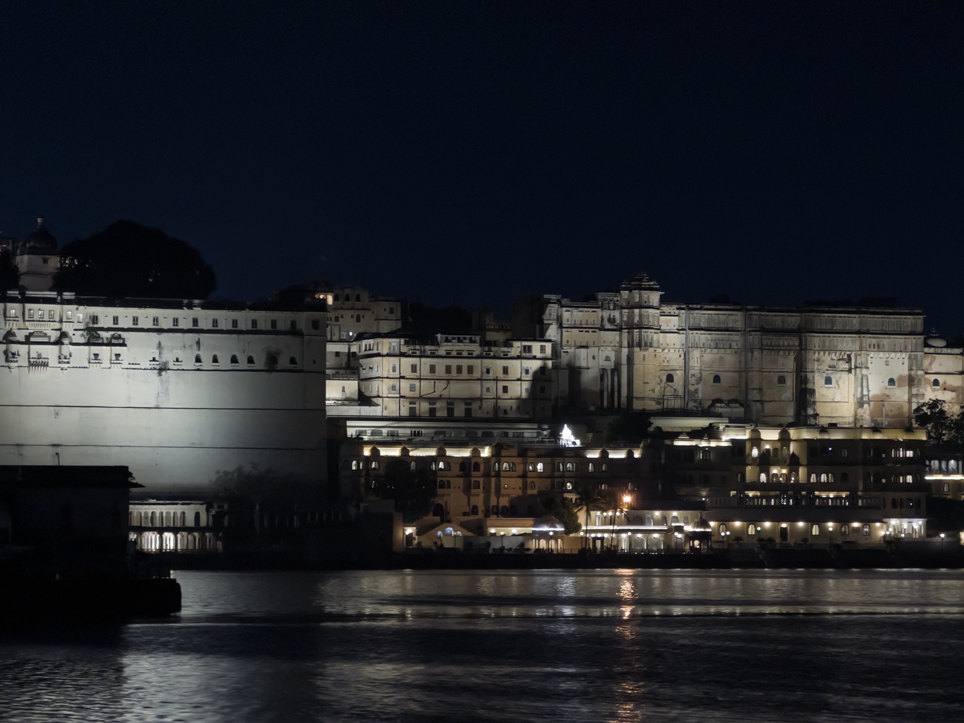 Illuminated buildings across Lake Pichola